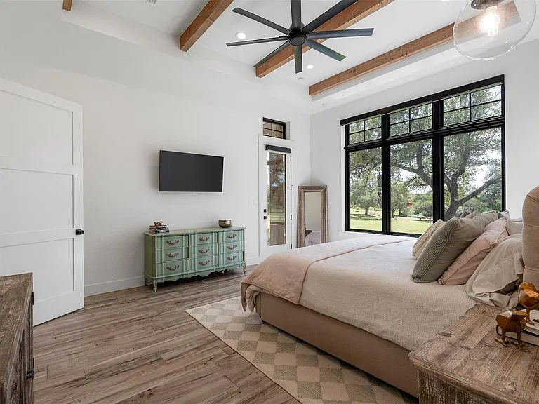 Bedroom with integrated television and automated window shades