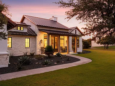 Driftwood residence exterior with coordinated landscape lighting at dusk