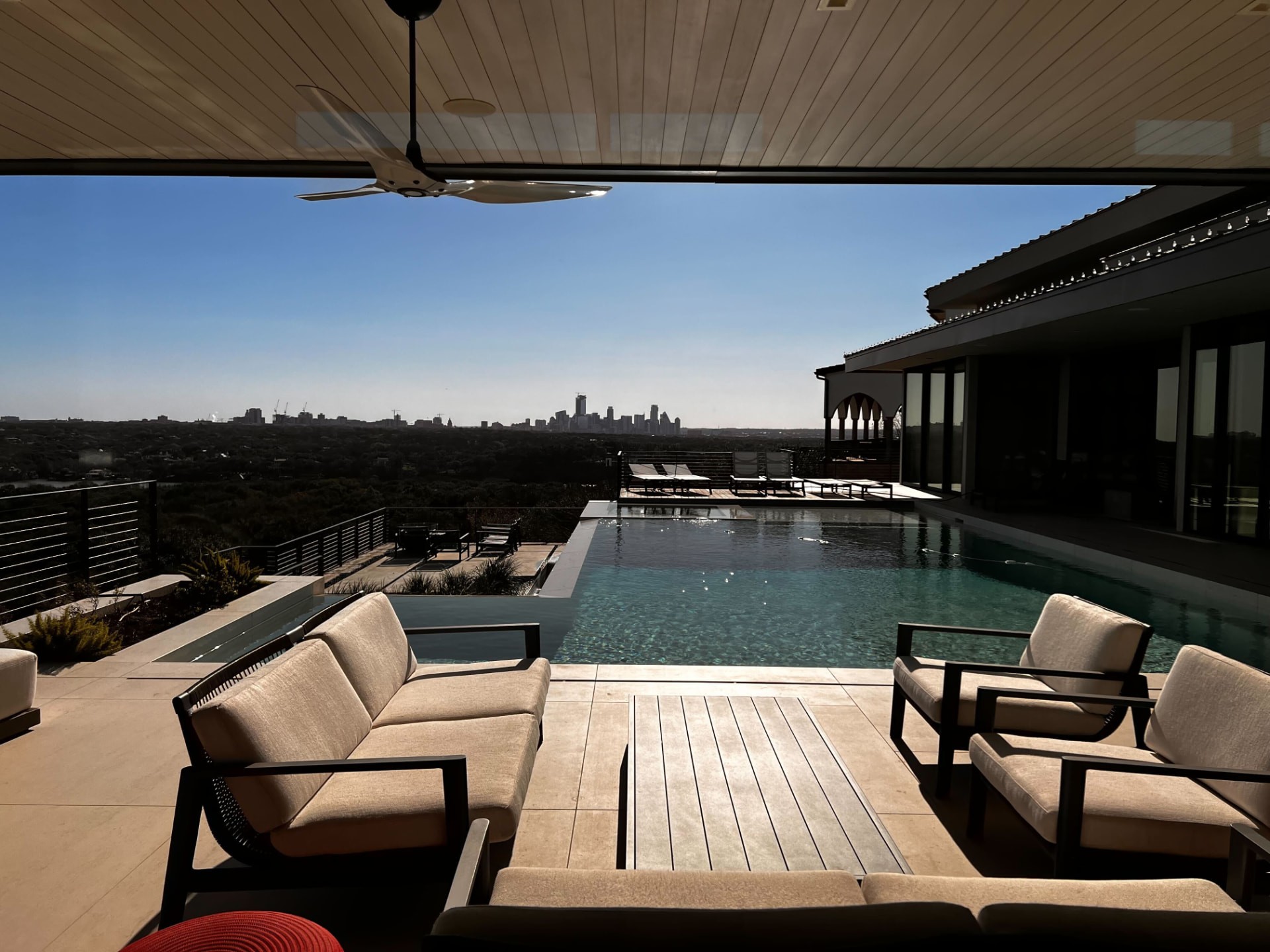 Covered patio with an infinity pool overlooking the downtown Austin skyline