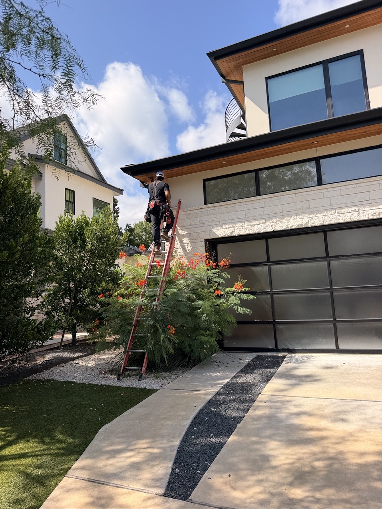 Technician working on the exterior of a modern home