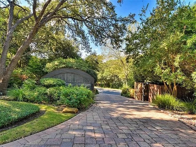 Paved drive and garden entry gates framed by mature oaks
