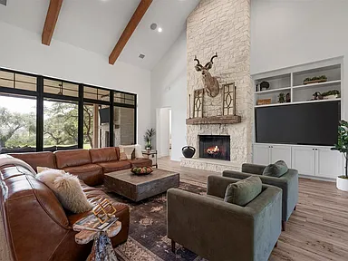 Living room with integrated television, fireplace, and architectural lighting