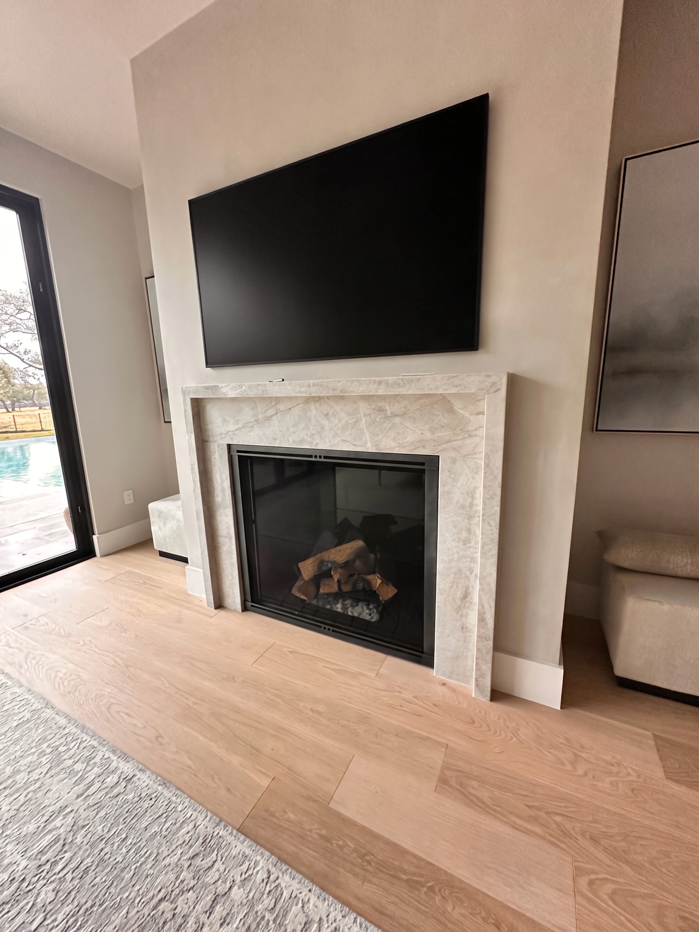 Marble fireplace with a wall-mounted television installed flush to the wall