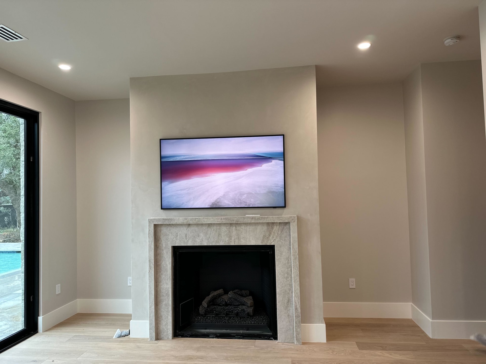 Living room fireplace wall with an integrated television and concealed wiring