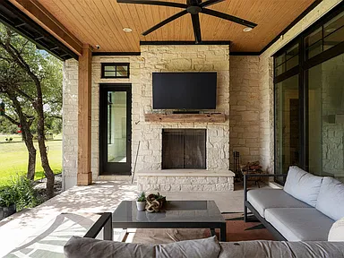 Covered patio with integrated television, fireplace, and ceiling fan