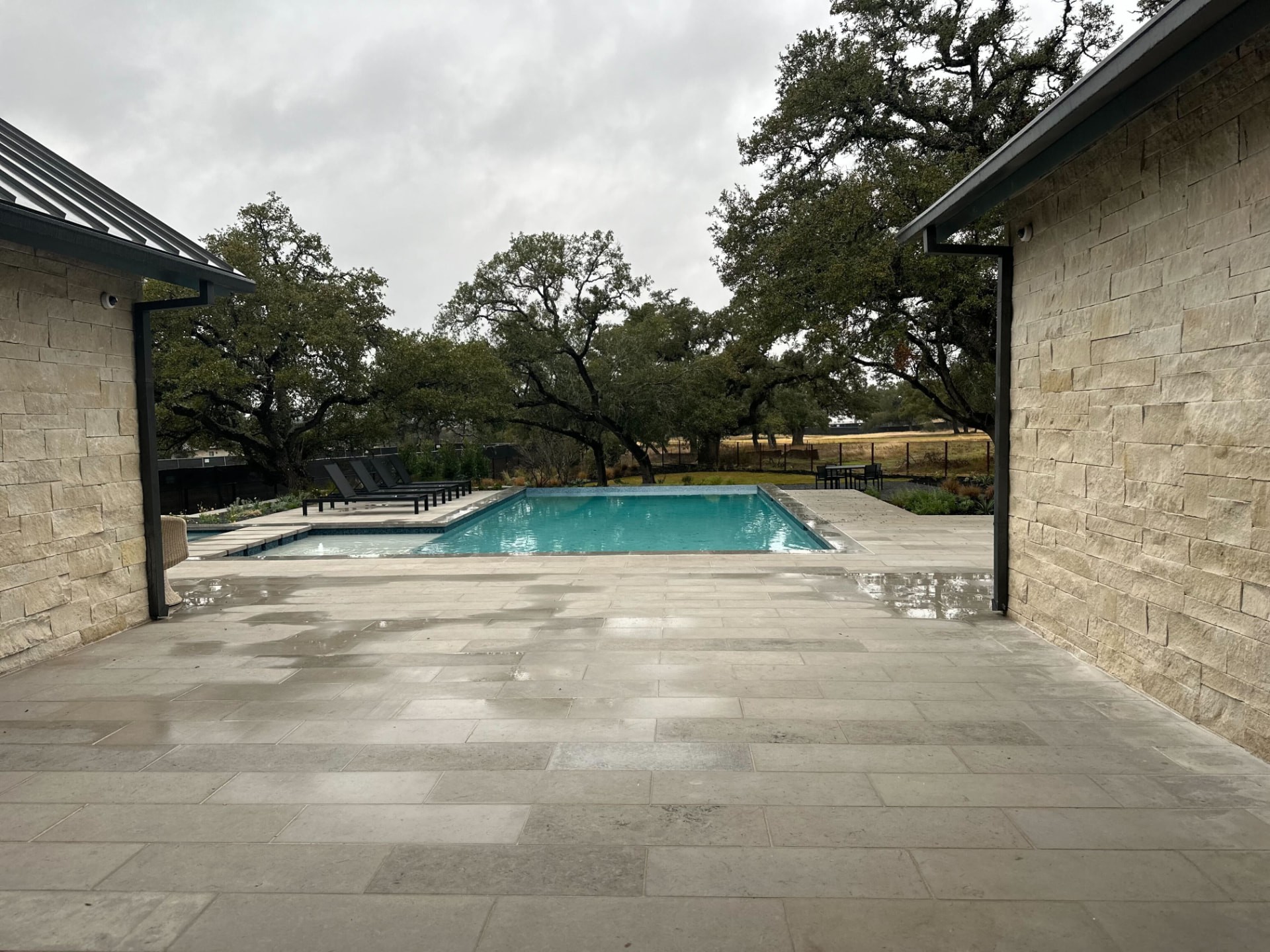Pool and stone terrace framed by the limestone wings of the residence