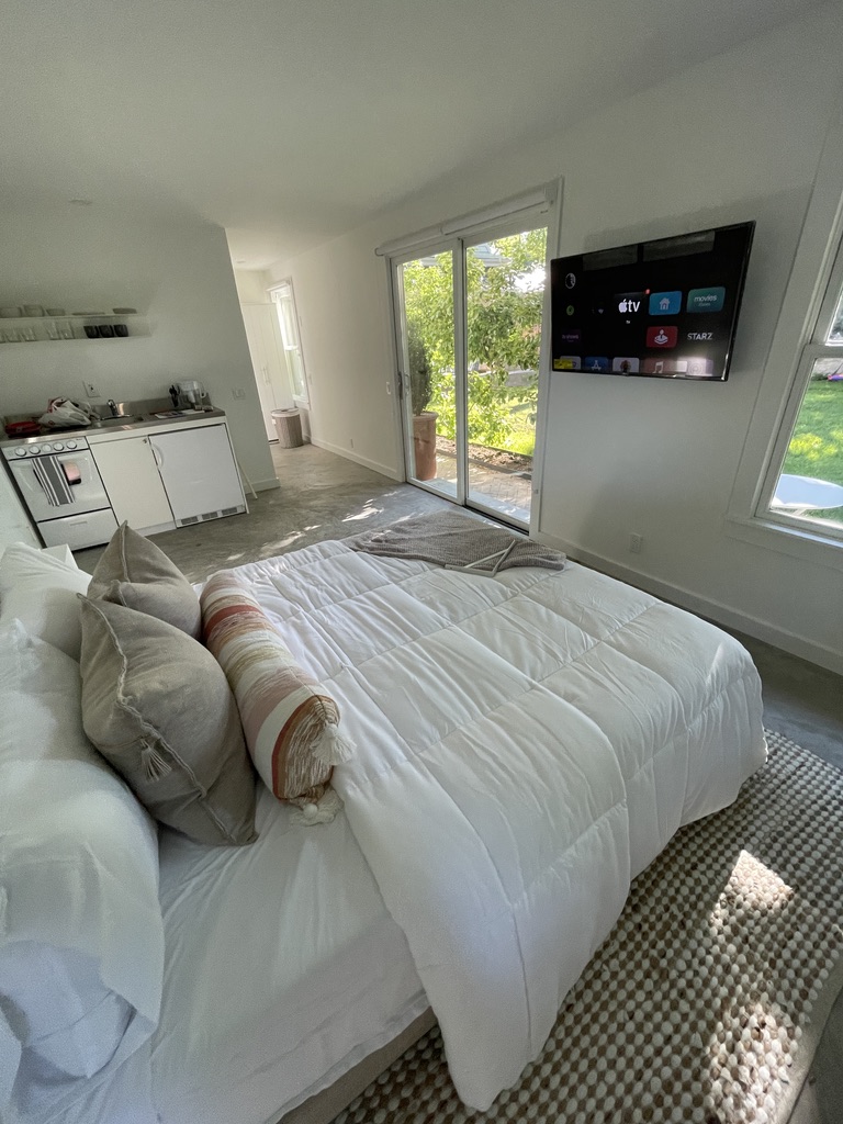 Finished guest suite with a discreet wall-mounted television