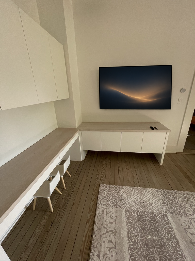 Media room with a wall-mounted television set into integrated cabinetry