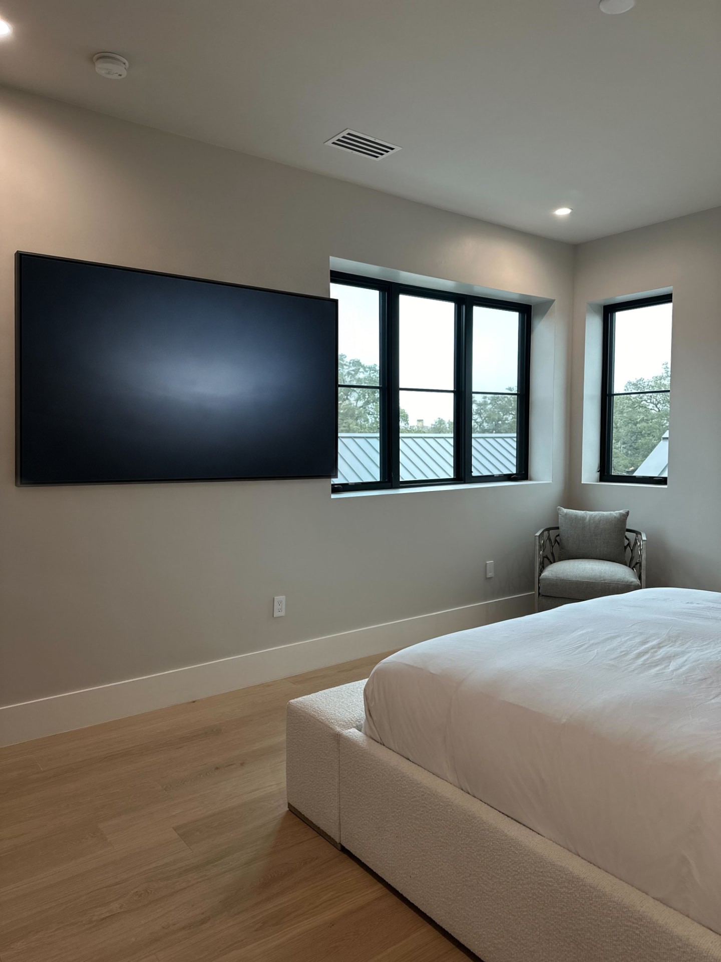 Bedroom with a wall-mounted television installed close to the wall