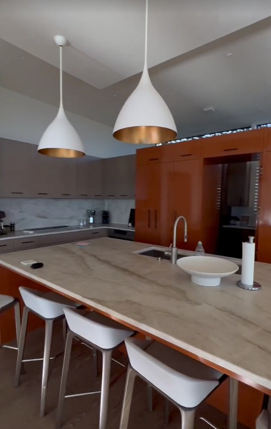 Kitchen with sculptural pendant lights, a marble island, and coordinated lighting